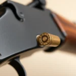 The 32WIN cartridge being inserted into a Winchester rifle, showcasing classic hunting gear and emphasizing firearm craftsmanship for enthusiasts and collectors.